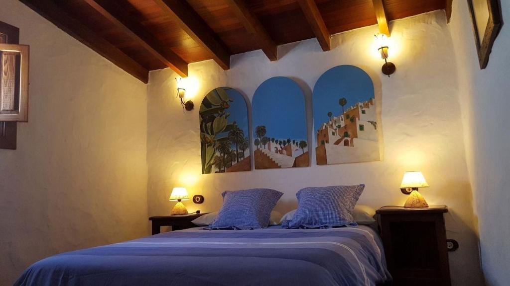 - une chambre avec un lit avec des draps bleus et deux lampes dans l'établissement Wunderschönes Ferienhaus in La Sorrueda mit Terrasse, Whirlpool und Grill, à La Sorrueda