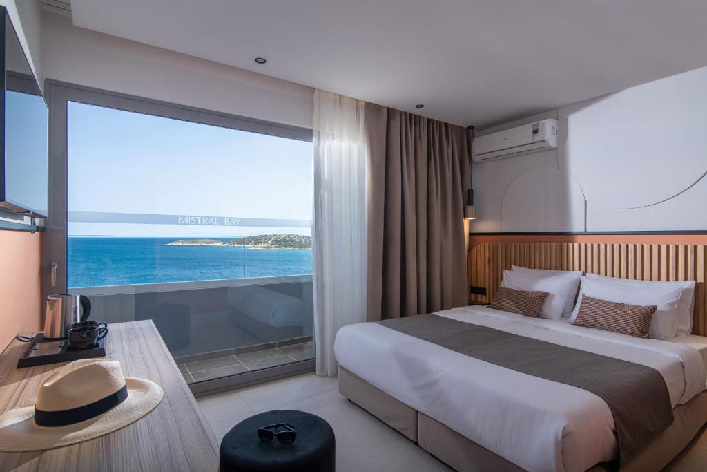 ein Schlafzimmer mit einem großen Bett und einem großen Fenster in der Unterkunft Mistral Bay Hotel in Agios Nikolaos