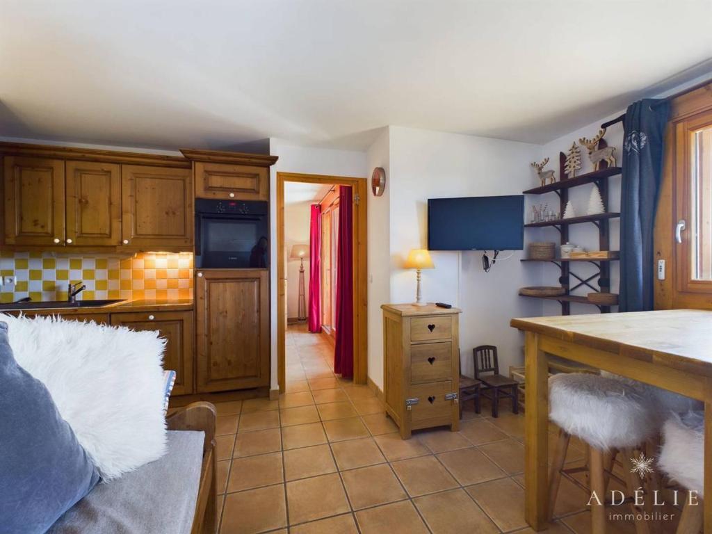 a kitchen with wooden cabinets and a table in a room at Appartement Montvalezan-La Rosière, 3 pièces, 6 personnes - FR-1-398-588 in Le Châtelard