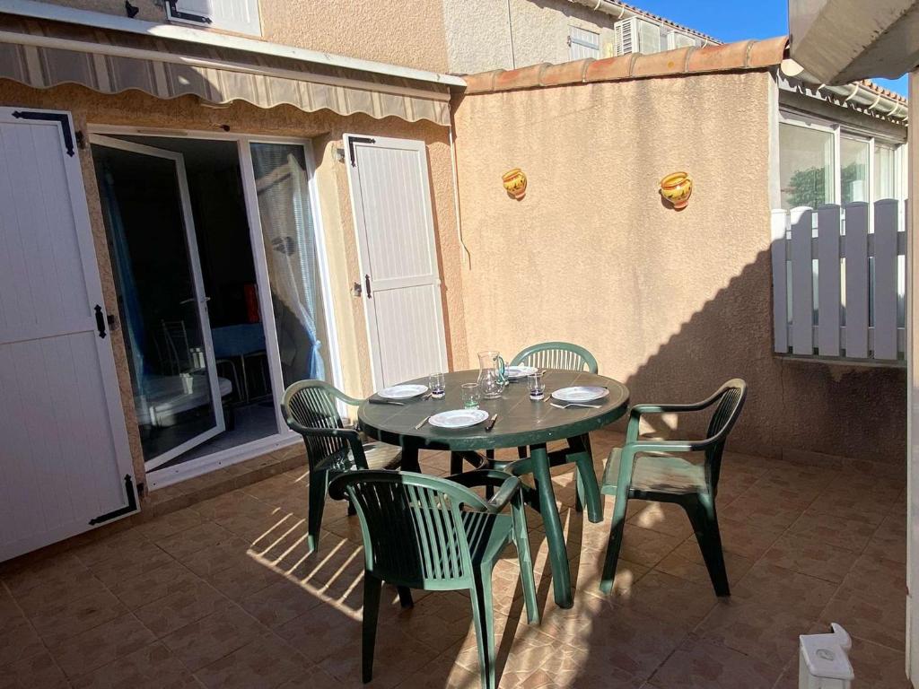 une table et des chaises assises sur une terrasse dans l'établissement Maison 3 pièces, 5 couchages avec terrasse et piscine, parking privé, à Marseillan - FR-1-326-705, à Marseillan