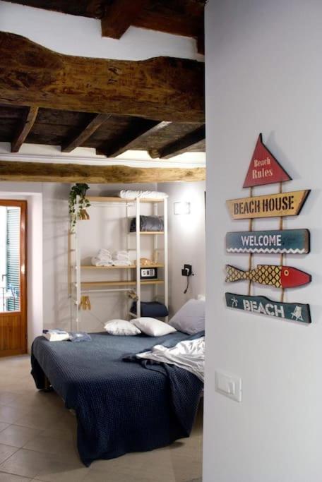 a bedroom with a bed and a sign on the wall at Appartamento Ca’ del Baffo @riocadelbaffo in Riomaggiore