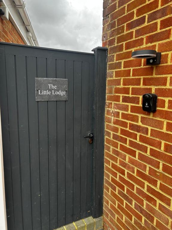 een zwarte poort met een bord dat de kleine ladder leest bij The Little Lodge in Horley