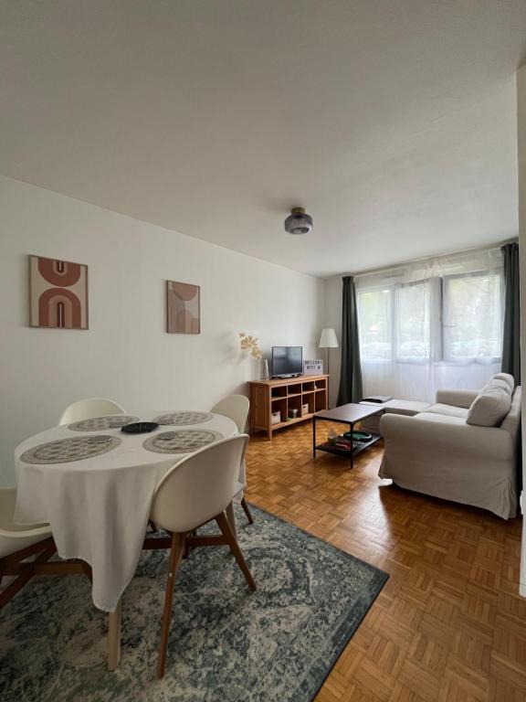 sala de estar con mesa y sofá en Appartement Cosy et Confortable en Saint-Genis-Laval