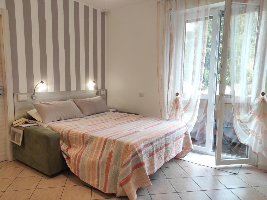 a bedroom with a bed and a large window at Como Petite Maison in Como