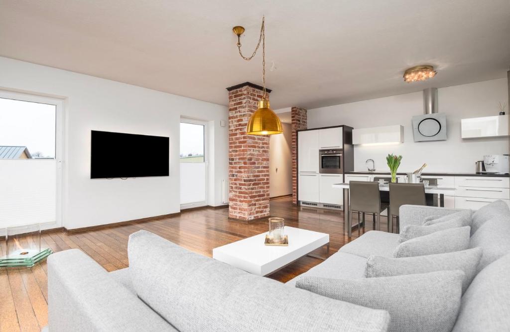 a living room with two couches and a table and a kitchen at Mugav suurepärase vaatega korter in Viljandi