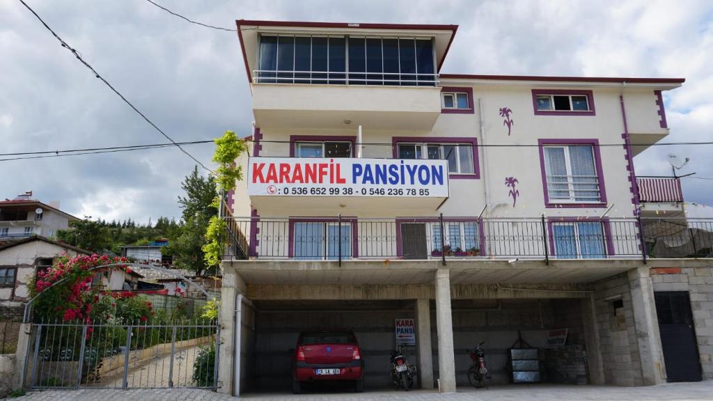 ein Gebäude mit einer Parkgarage davor in der Unterkunft Salda Karanfil Pansiyon in Yeşilova
