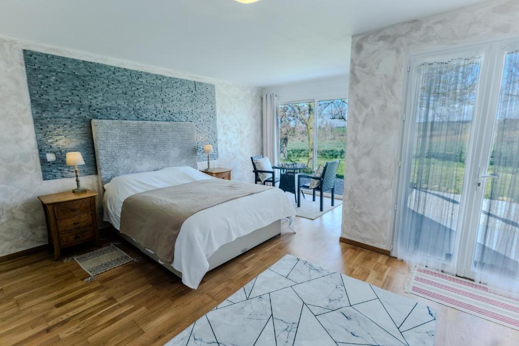 a bedroom with a bed and a table and chairs at Chez PhiL - Le calme proche de Revel, Castelnaudary, Carcassonne in La Pomarède