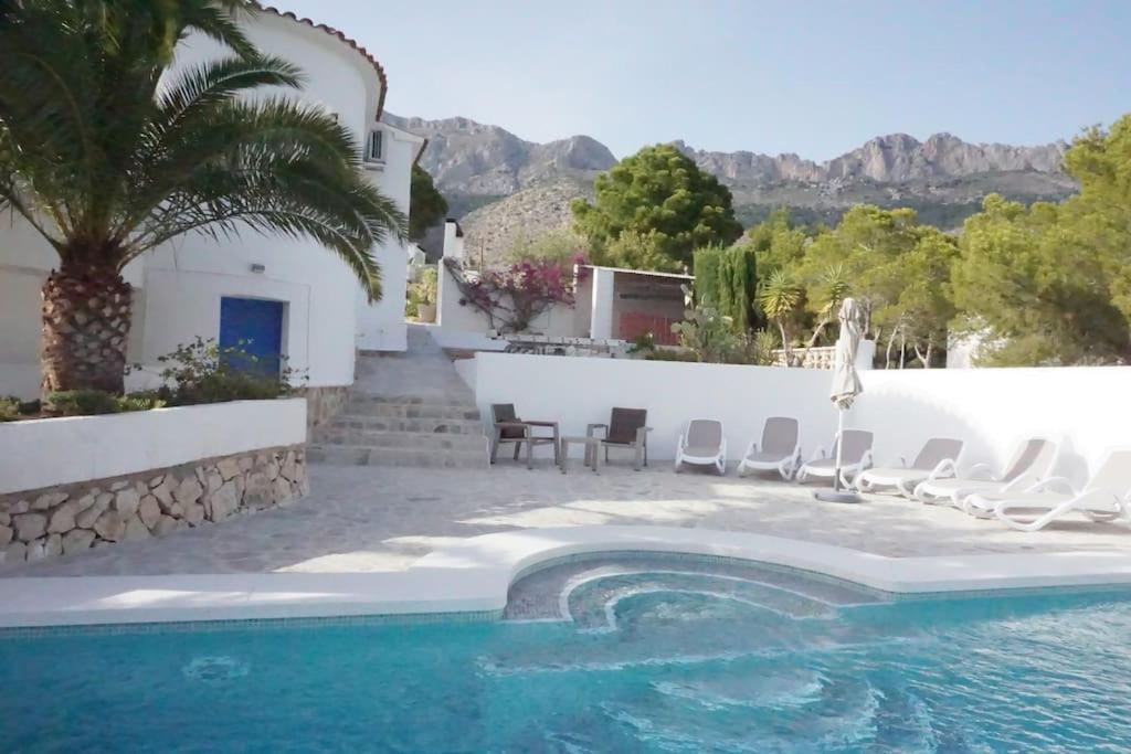 - une piscine avec des chaises et une maison dans l'établissement Villa with spectacular vieuw and swimmingpool., à Altea