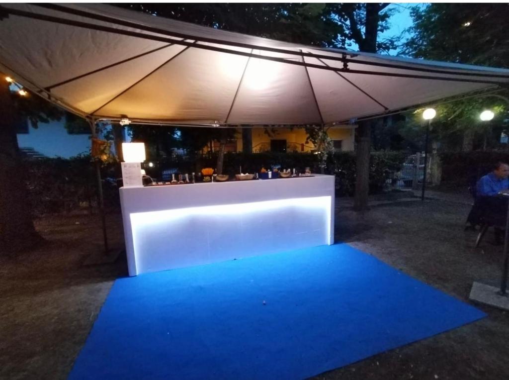 a blue carpet is lit up under an umbrella at C.R.D.D. Due Torri Riccione in Riccione