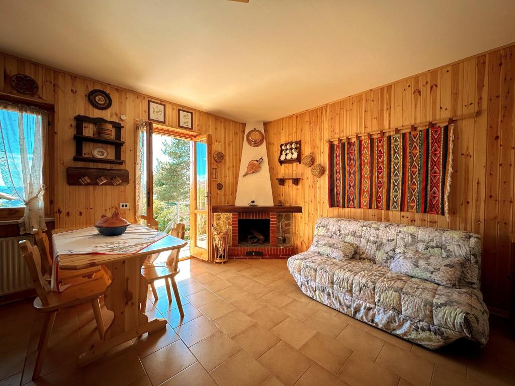 een woonkamer met een bank en een tafel bij NIDO RUSTICO TRA I MONTI in Rocca Cinquemiglia