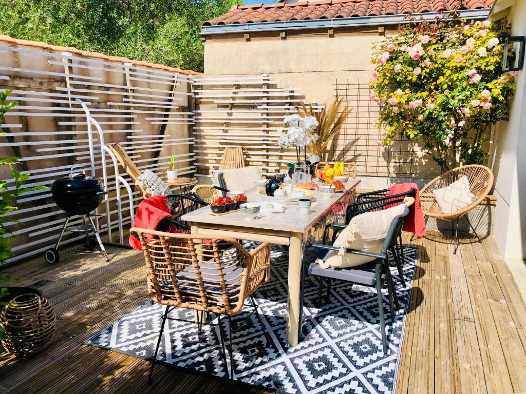 un patio avec une table et des chaises sur une terrasse dans l'établissement Villa Einigriv, à Châtelaillon-Plage