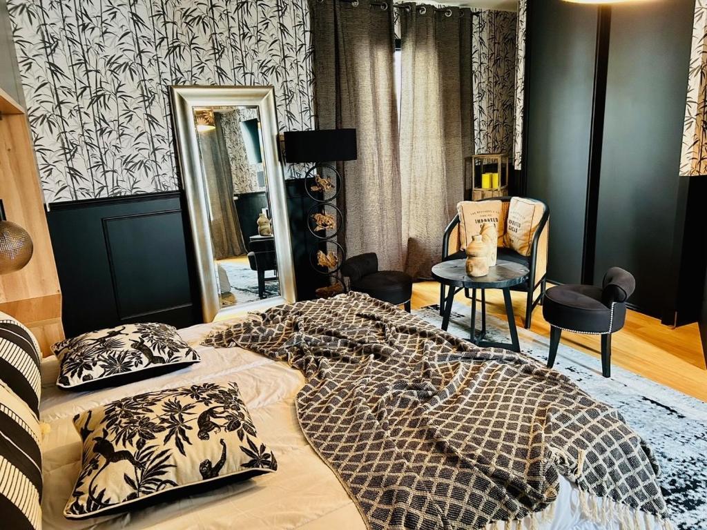 a bedroom with a large bed and a mirror at Villa Einigriv in Châtelaillon-Plage