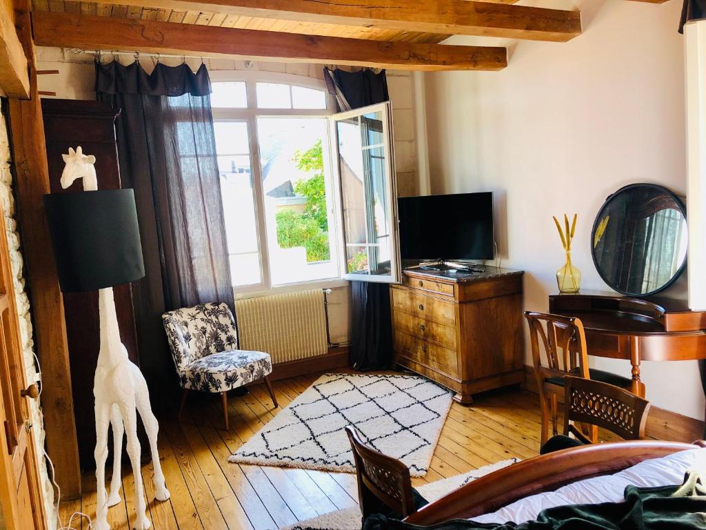 a living room with a bed and a tv at Villa Einigriv in Châtelaillon-Plage