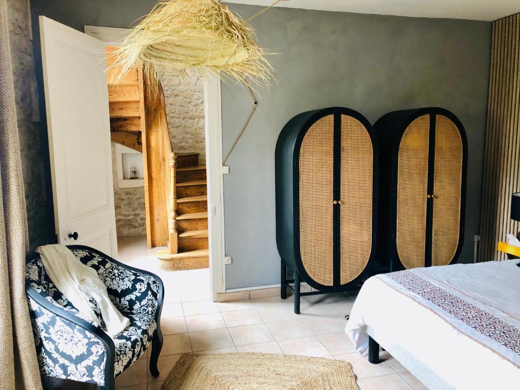 a bedroom with a bed and two chairs in a room at Villa Einigriv in Châtelaillon-Plage