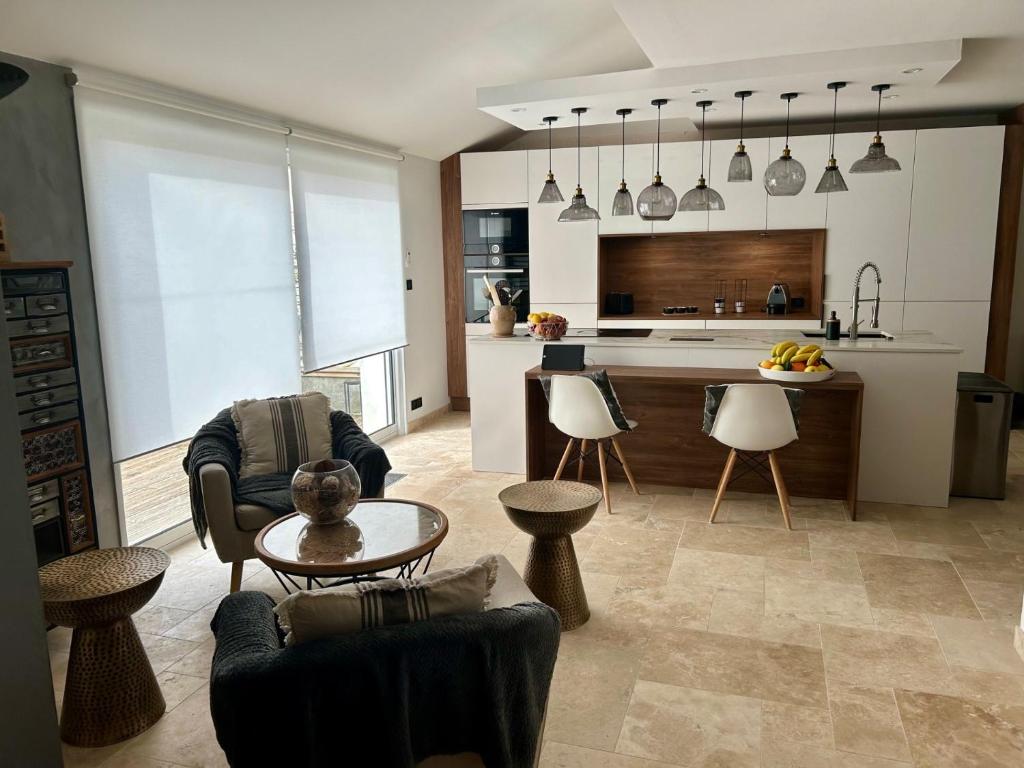 a kitchen and living room with chairs and a table at Villa Einigriv in Châtelaillon-Plage