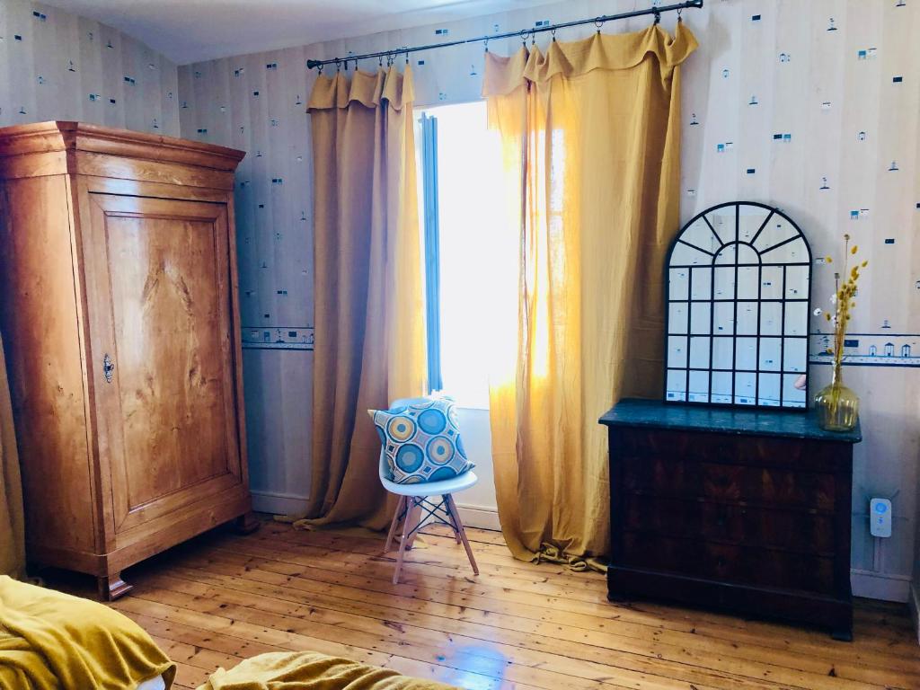 a bedroom with a bed and a dresser and a window at Villa Einigriv in Châtelaillon-Plage