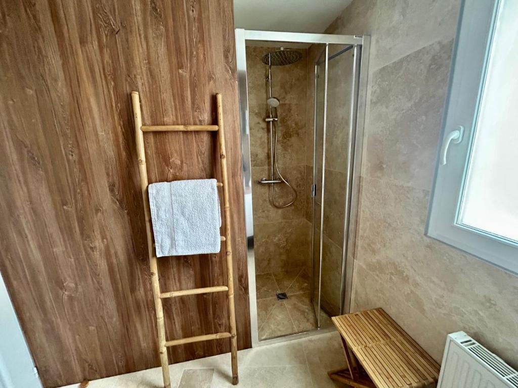 a bathroom with a shower with a wooden wall at Villa Einigriv in Châtelaillon-Plage