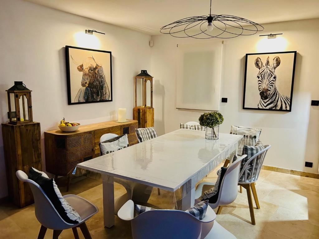a dining room with a white table and chairs at Villa Einigriv in Châtelaillon-Plage