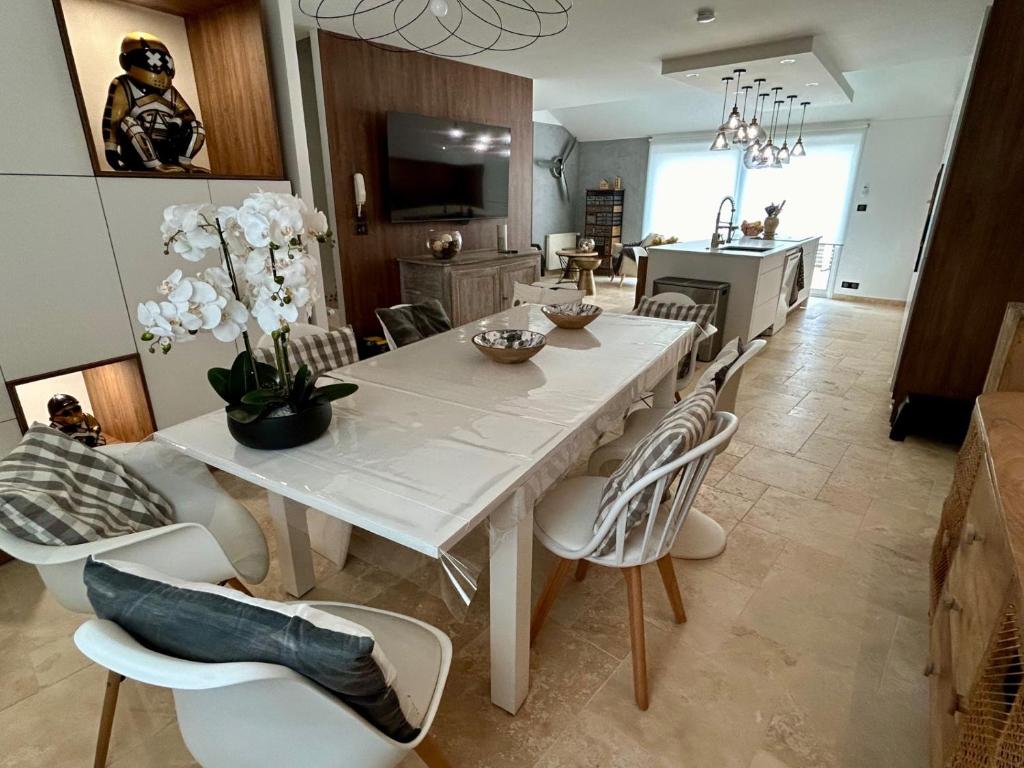 a dining room and kitchen with a white table and chairs at Villa Einigriv in Châtelaillon-Plage