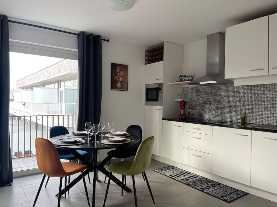 Appartamento ideal في تيلت: مطبخ مع طاولة وكراسي ومطبخ مع نافذة