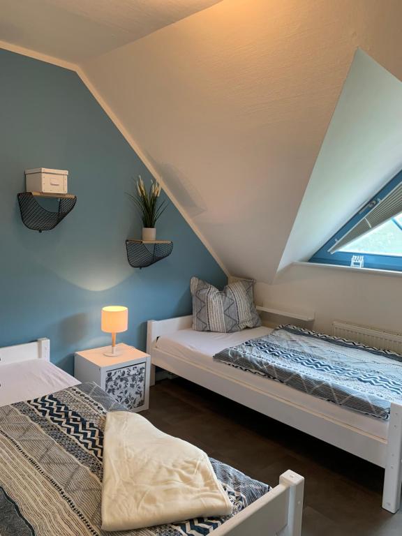 a attic bedroom with two beds and a window at Schwalbennest in Zingst