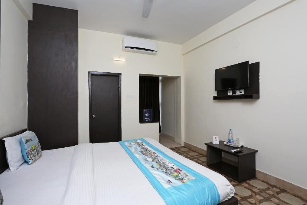 a bedroom with a bed and a flat screen tv at Stellar Resort in Bhubaneshwar
