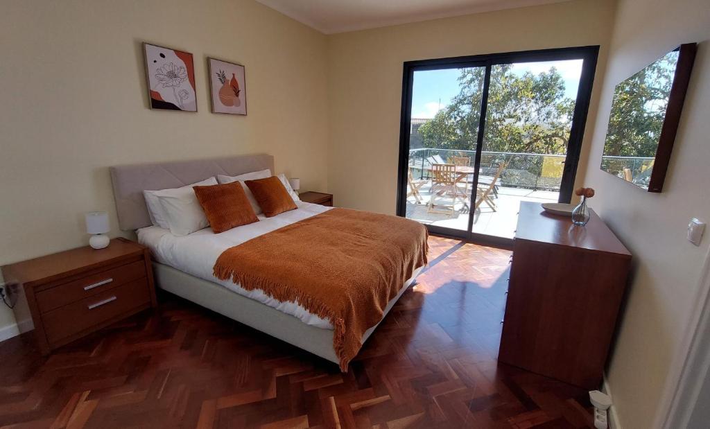 um quarto com uma cama e uma grande janela em Villa Strelitzia em Funchal
