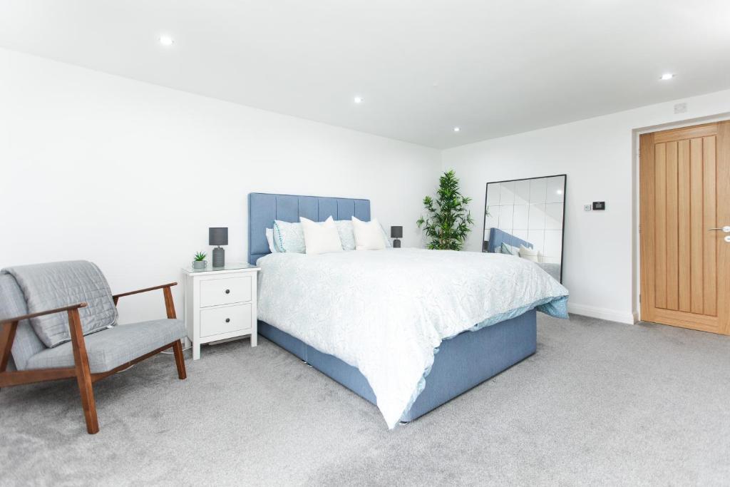 - une chambre avec un lit, une chaise et un miroir dans l'établissement Garden Apartment - Close to Town Centre - sleeps 6, à Buxton