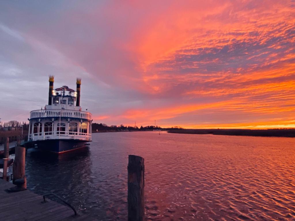 a ferry boat on the water with a sunset at Schwalbennest in Zingst