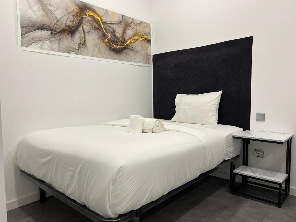 Laniakea Suites في لشبونة: غرفة نوم عليها سرير وفوط