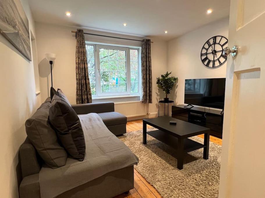 a living room with a couch and a table at 3 Bed luxury house, 10 min walk to underground in London