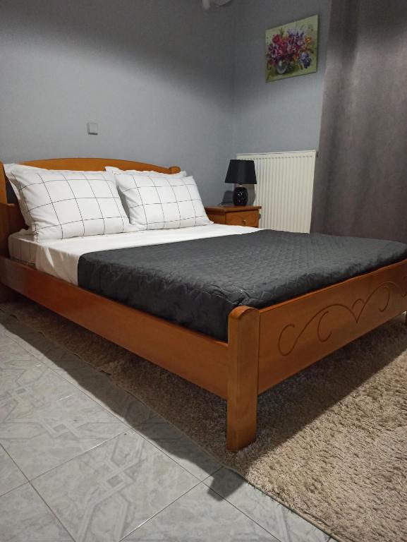 uma cama grande com uma estrutura de madeira num quarto em Lardos Apartment em Lardos