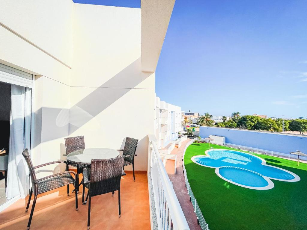 balcón con mesa y sillas y suelo verde en Modern Three bed Apartment, en San Pedro del Pinatar