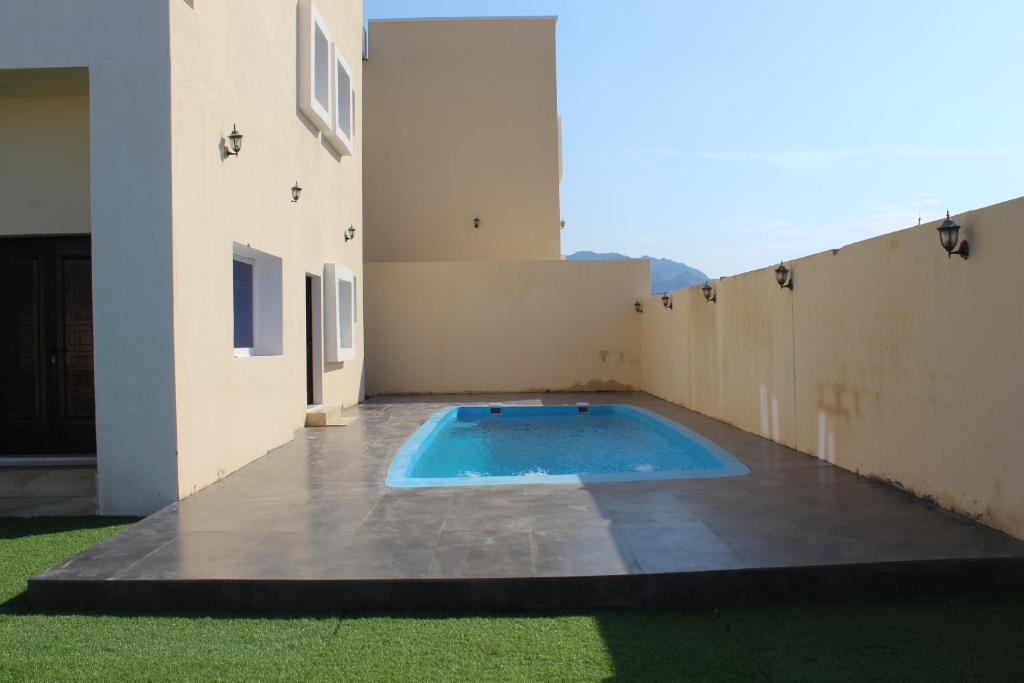 a swimming pool on the side of a house at Dreams Resorts in Sinādil