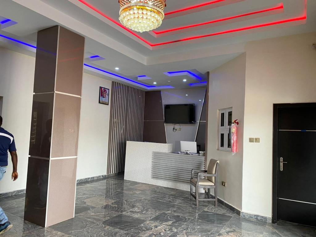 a lobby with blue lights on the ceiling and a chair at Diamond Castle Hotel in Owerri