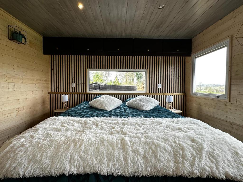 ein Schlafzimmer mit einem großen Bett mit zwei Kissen darauf in der Unterkunft La Cabane D'Emma Spa&Sauna privé in Bannalec