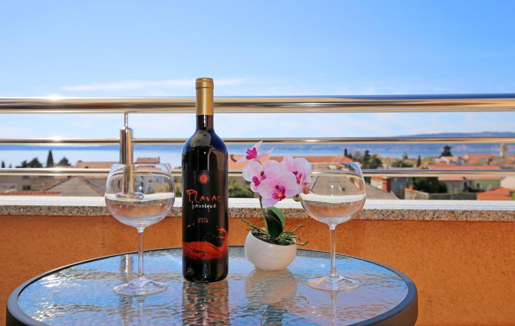una bottiglia di vino seduta su un tavolo con due bicchieri di Top apartment a Kaštela (Castelli)