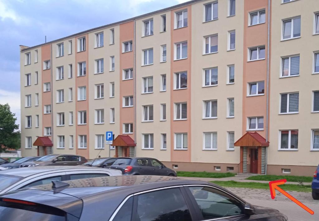 a large building with cars parked in a parking lot at M2 Art in Giżycko