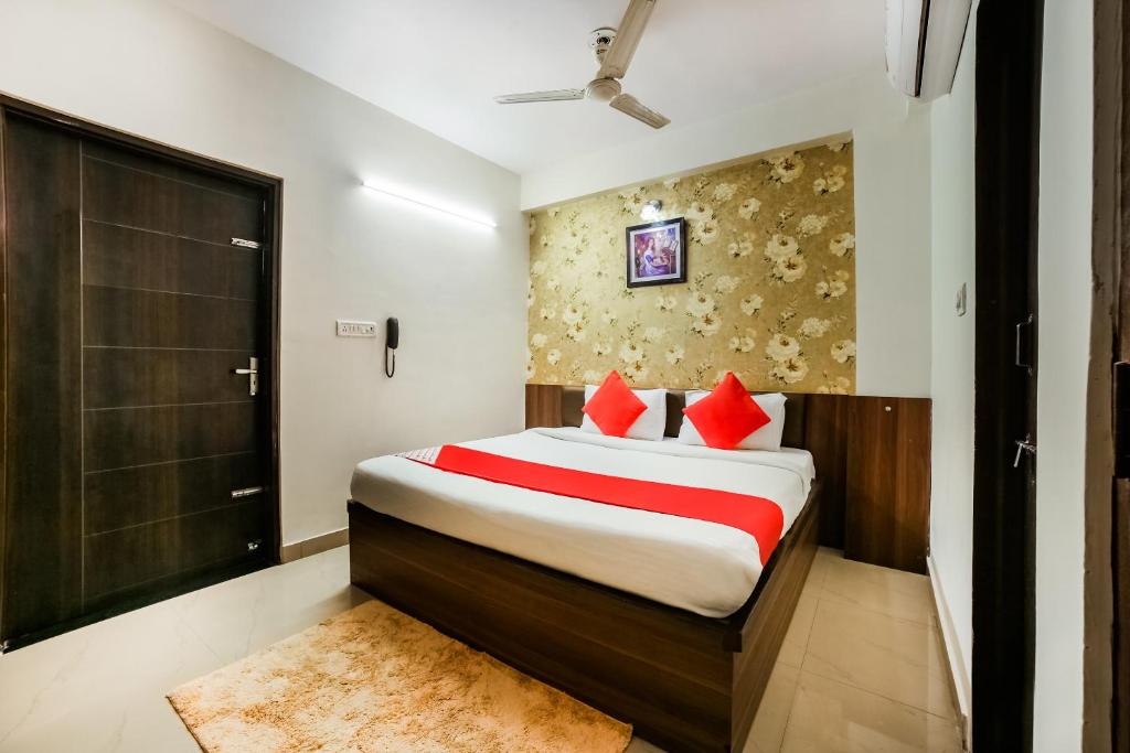 sypialnia z łóżkiem z czerwonymi poduszkami w obiekcie Super OYO AARAV HOTEL w mieście Dżajpur