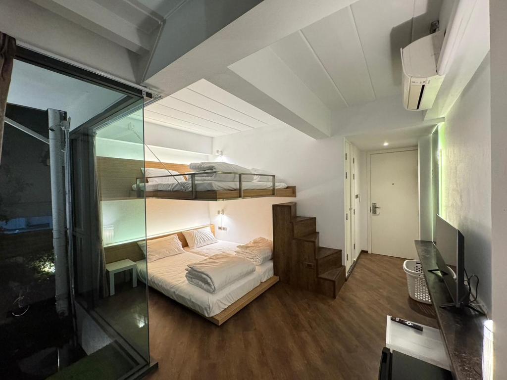 チェンマイにあるOne More Spaceのベッドルーム1室(二段ベッド1組、ガラスの壁付)