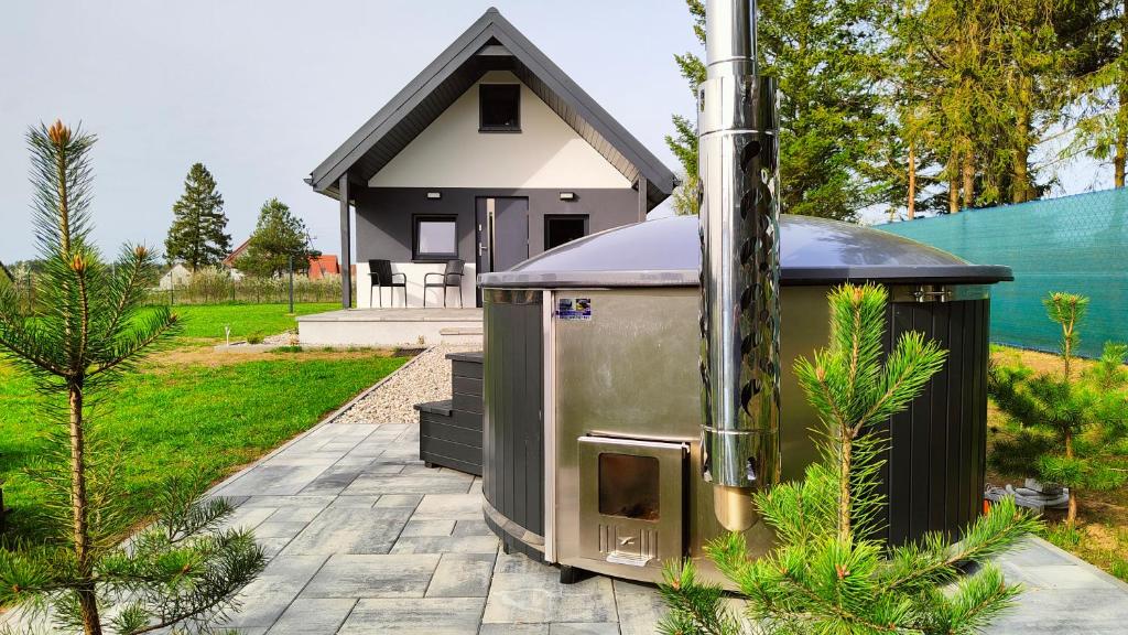 a small house with a stove in a yard at Na Zaciszu in Cierzpięty