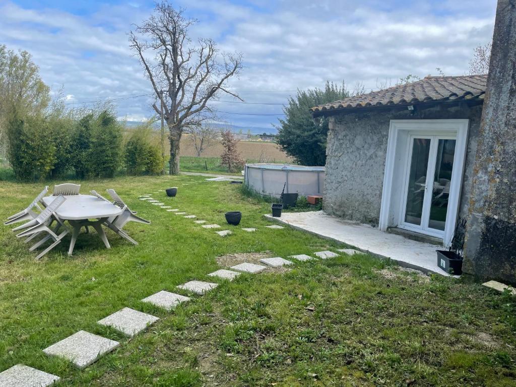 un patio trasero con una mesa de picnic y un edificio en Domaine des mirages, en Mas-Saintes-Puelles
