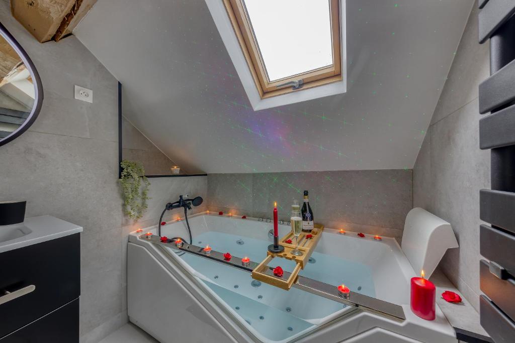 een badkamer met een bad met kaarsen en een raam bij Romantique love room / 15mn Fontainebleau in Montereau-faut-Yonne