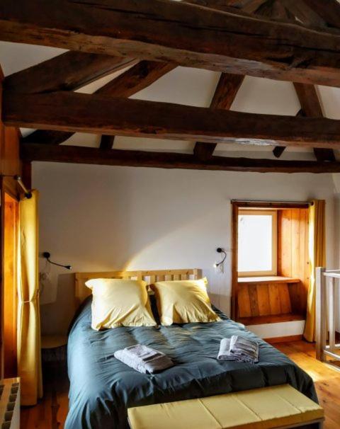 une chambre avec un lit avec des draps bleus et une fenêtre dans l'établissement La ch'tiote meizou, à Mazet-Saint-Voy