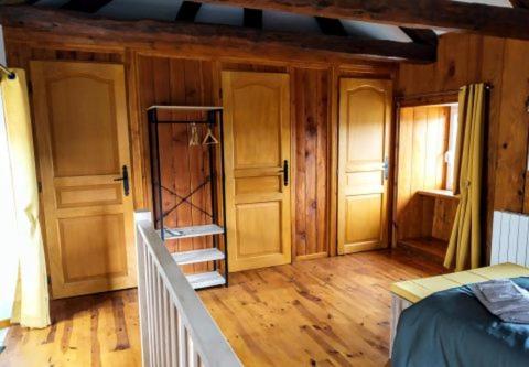 a room with wooden floors and a room with a bed at La ch&#39;tiote meizou in Mazet-Saint-Voy