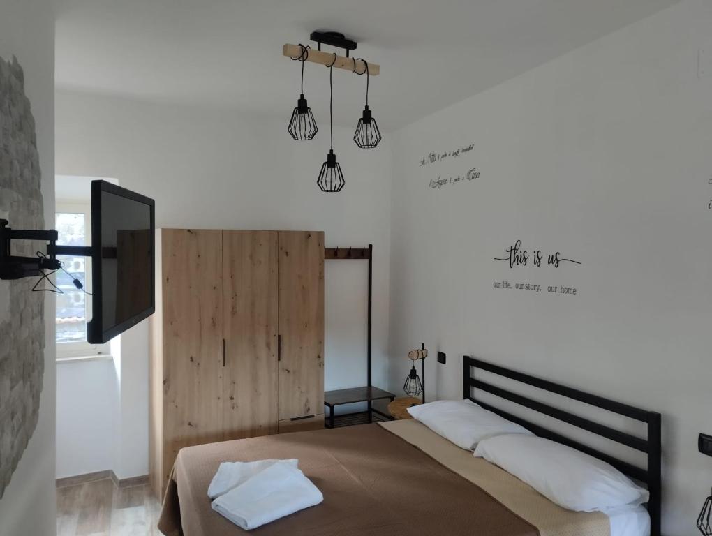 1 dormitorio con 1 cama con 2 almohadas y TV en La Casa dei Ricordi, en Campagnano di Roma