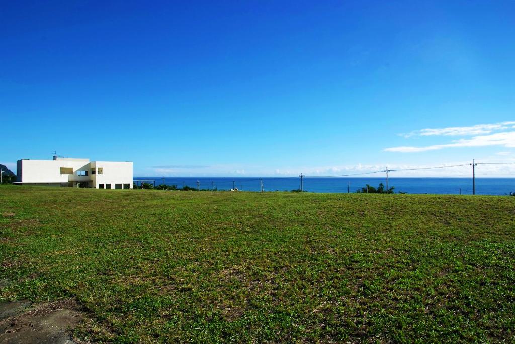 a white building on top of a grass field at The Blue Lagoon B&amp;B in Fengbin