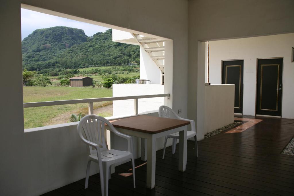 a table and chairs on a balcony with a view at The Blue Lagoon B&amp;B in Fengbin