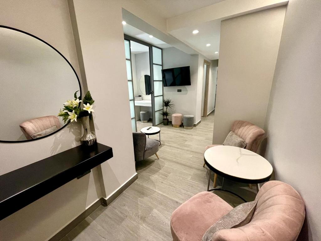 um quarto com duas cadeiras, uma mesa e um espelho em Urban Suite em Iráclio