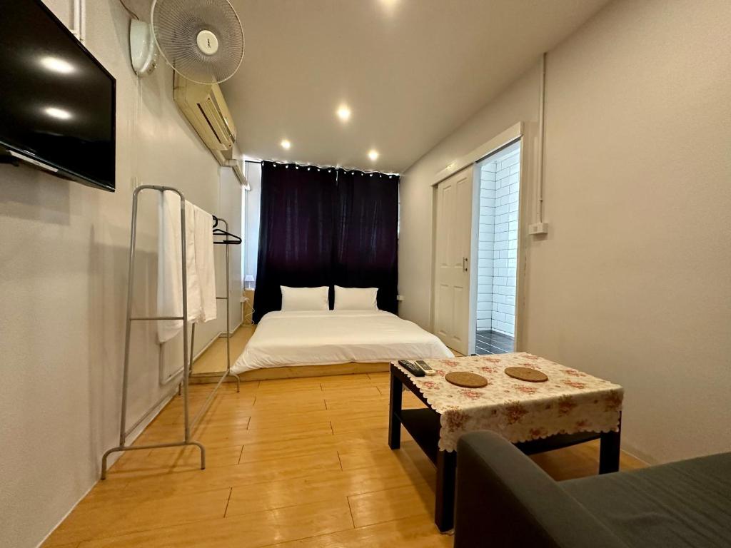 Un dormitorio con una cama y una mesa. en The Cute Silom hostel, en Bangkok